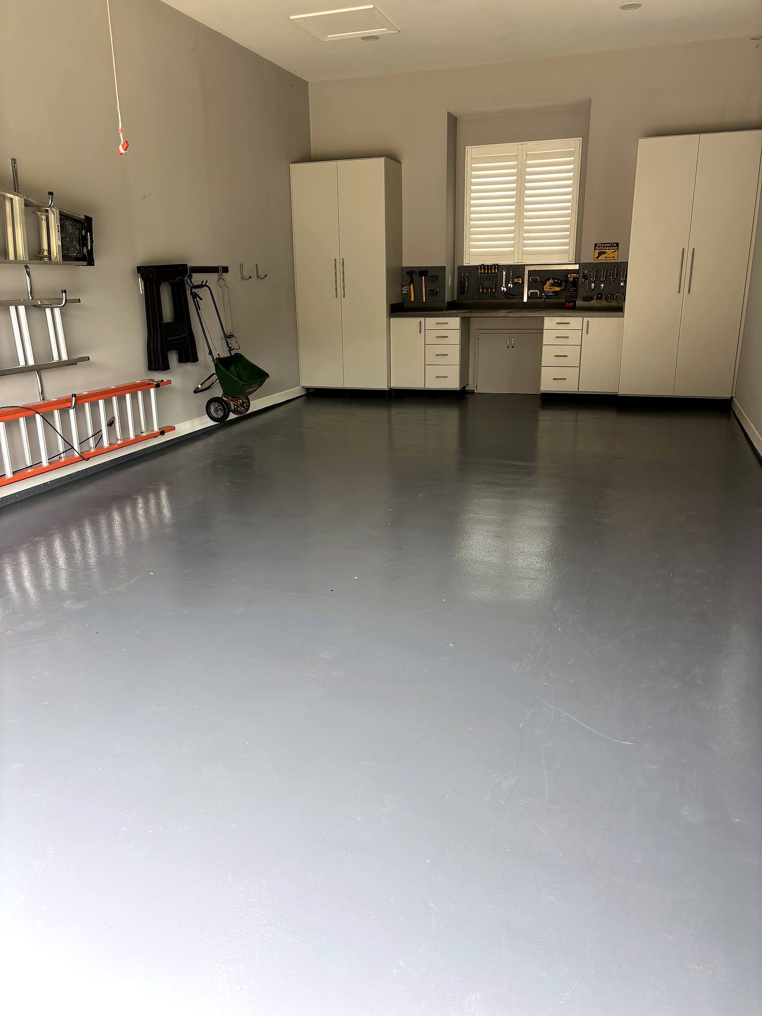 Custom cabinets, pegboard workbench, and graphite epoxy floor