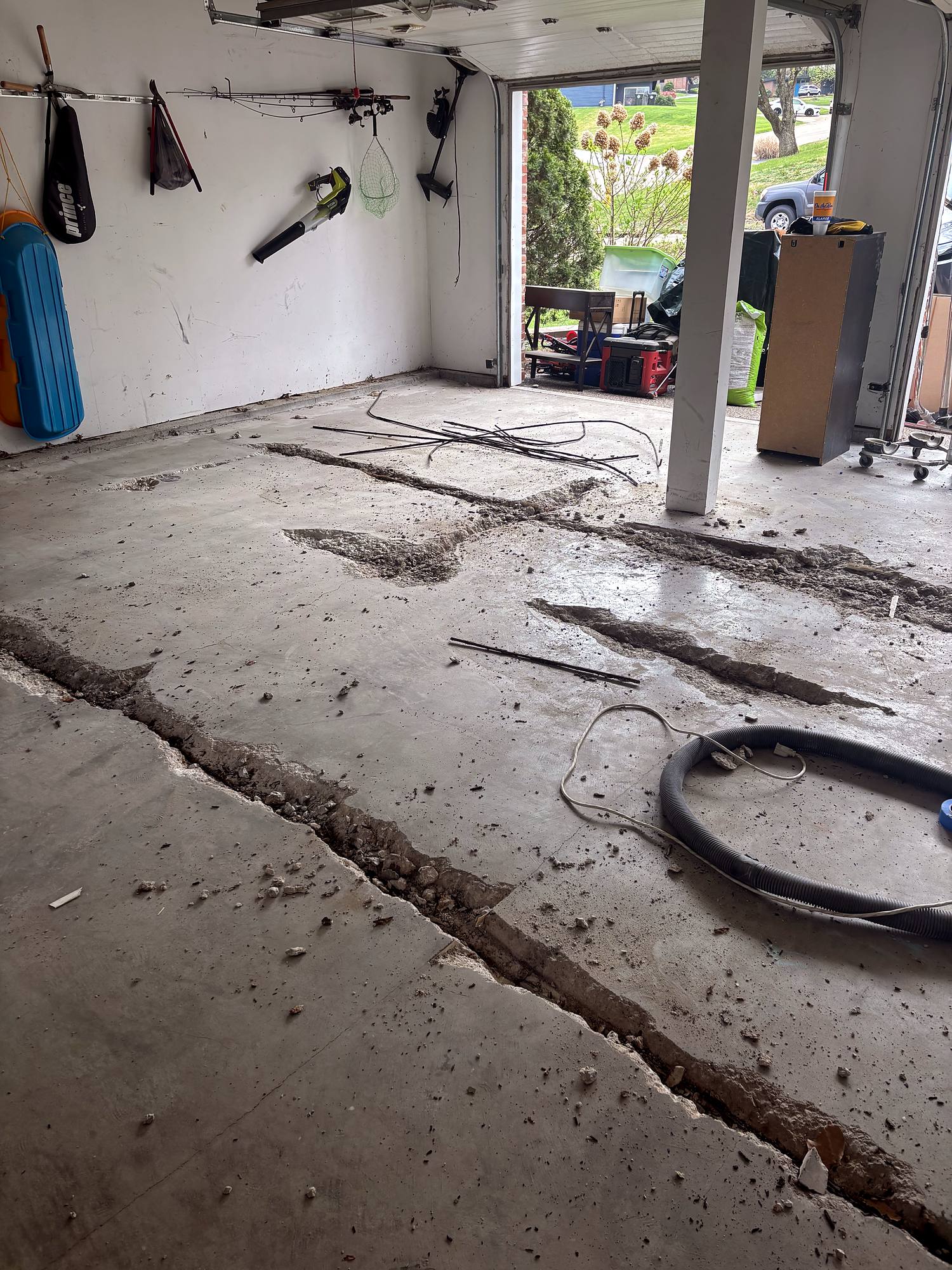 Cracked garage slab with rebar exposed before repair